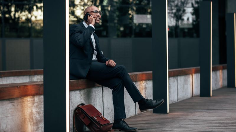Businessman on phone while sitting outside