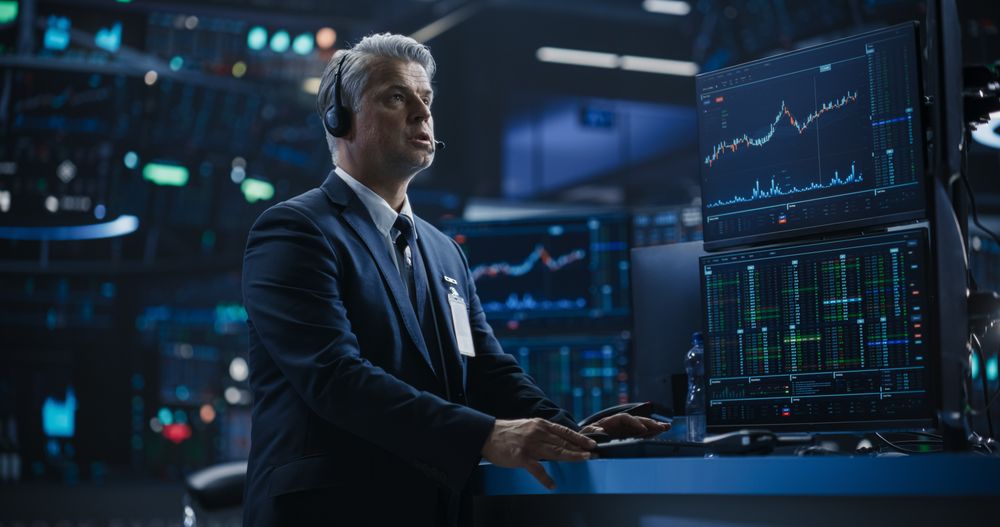 Portrait of a Stock Exchange Broker Working on Computer with Multi-Screen Workstation with Real-Time Stocks, Commodities and Exchange Market Charts.