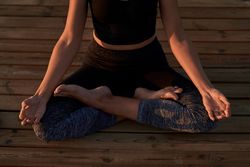 Unrecognizable woman meditating in nature