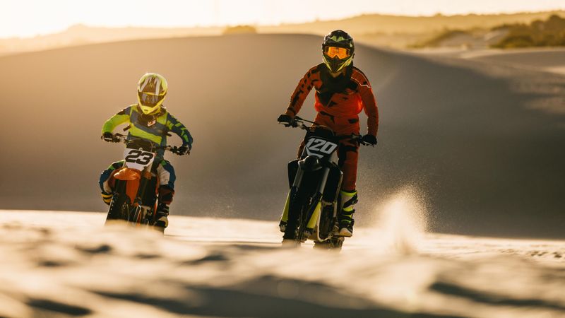Professional dirt bikers racing on sand dunes