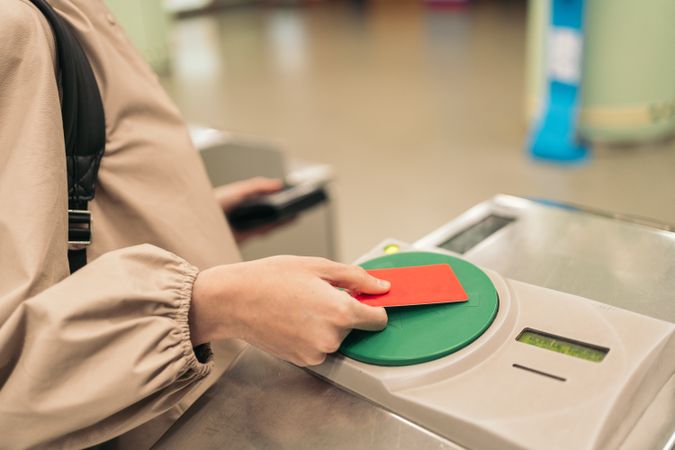 Young woman using the ticket to entering to the metro