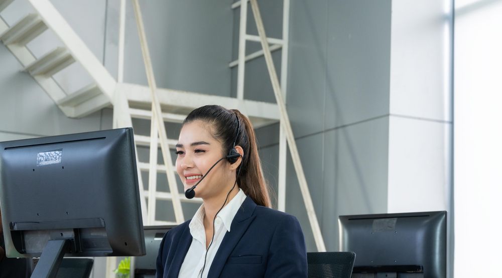 Female speaking on headphones in call center