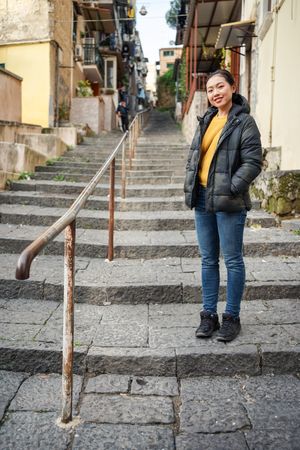 woman standing on steps on shabby street