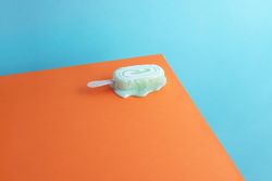 One melting mint colored ice cream popsicle