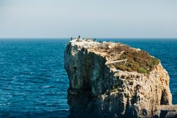 Rough cliff in blue sea