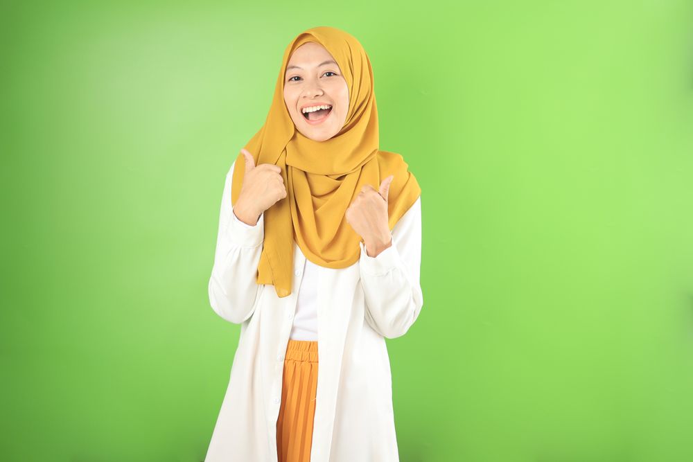 Young Asian Muslim Woman Smiling and Making Thumbs Up  Gesture