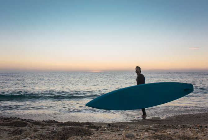 Man practicing paddle surfing with neoprene in a sunrise