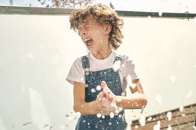 Screaming boy having fun while doing household chores