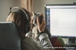 Woman petting her cat while working on desktop computer 5ryo30
