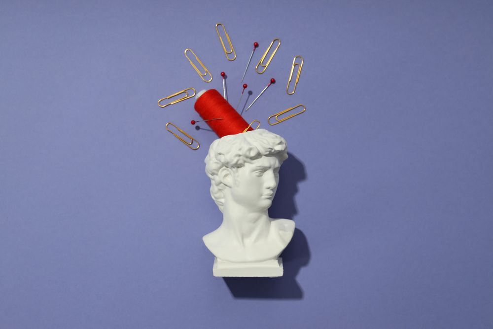 Pins and red spool in bust on purple background