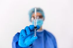 Healthcare worker holding needle