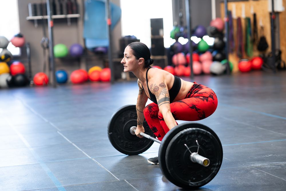 Athletic woman deadlifting bar bell