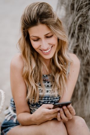 female using smartphone on beach