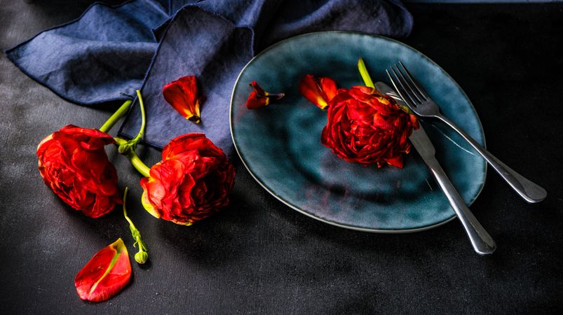 Red flowers with blue plate and cutlery