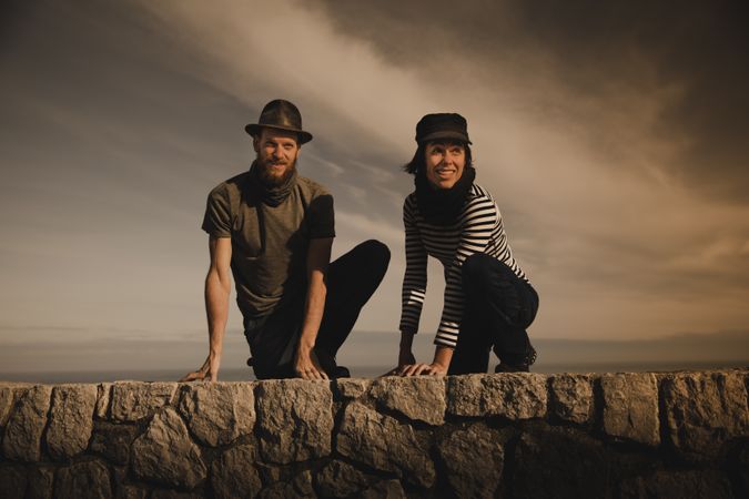 Man and woman leaning out from stones