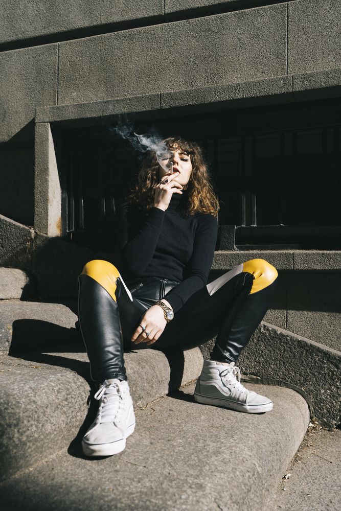 Young woman smoking cigarette in the street