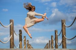 Woman with textile posing in air on footbridge