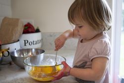 Girl mixing eggs in the kitchen