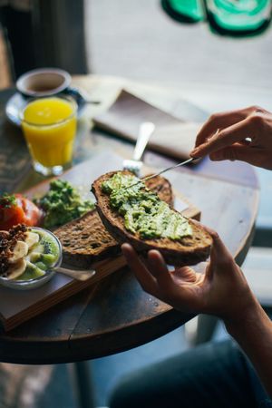 Person with avocado toast enjoying a healthy breakfast