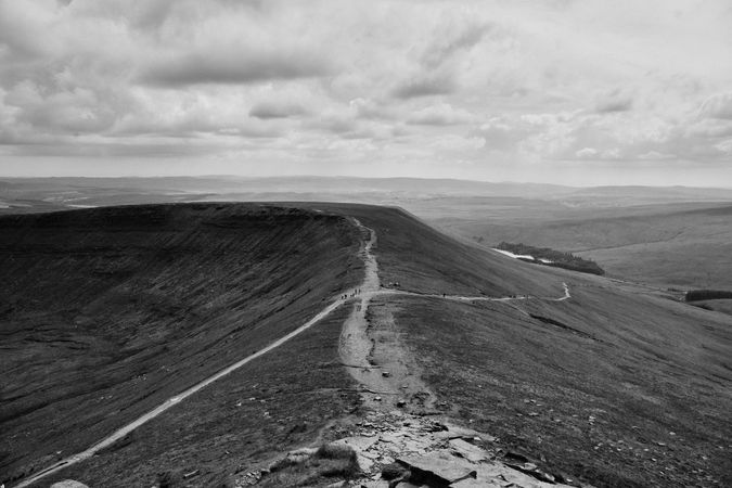 Monochrome picture of people walking on a trail in the Brecon Beacons mountain range
