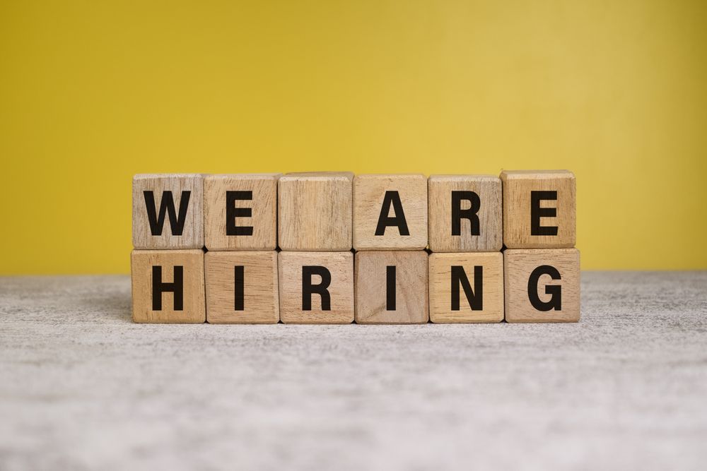 we are hiring words on wooden blocks on yellow background