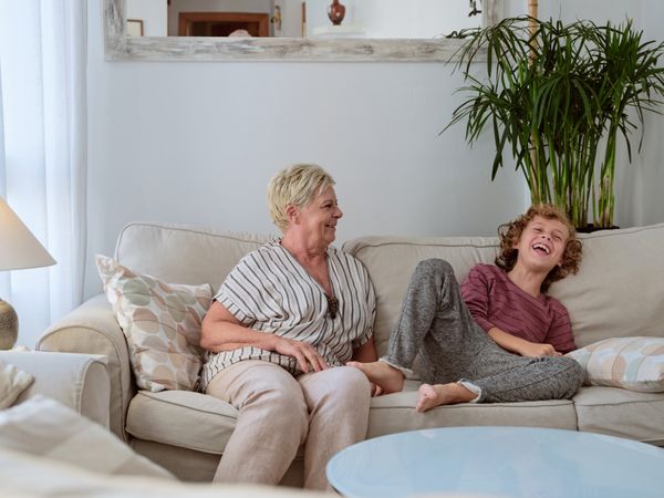 Grandmother sitting on couch with grandson