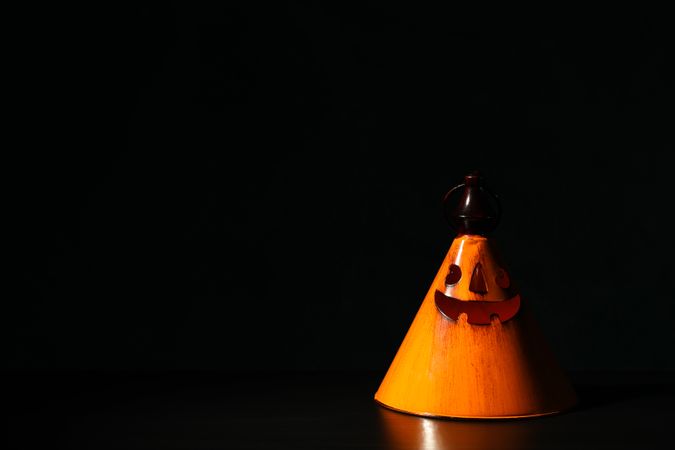 Orange halloween candlestick on dark background, copy space
