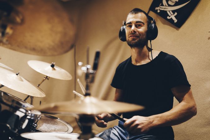 Man with headphones playing on drums