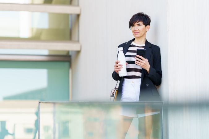 Woman taking break outside building with bottle