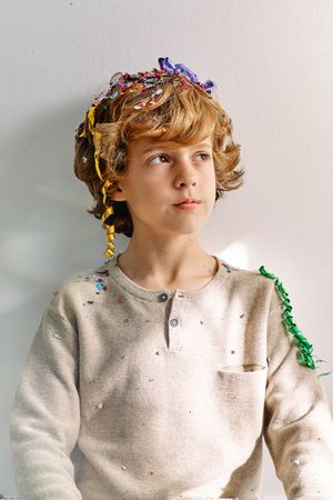 Dreamy schoolboy with confetti of firecracker
