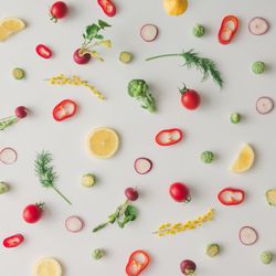 Colorful vegetable pattern made of lemon, tomatoes, broccoli and yellow flowers