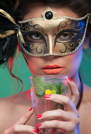 Woman in mask holding glass of drink