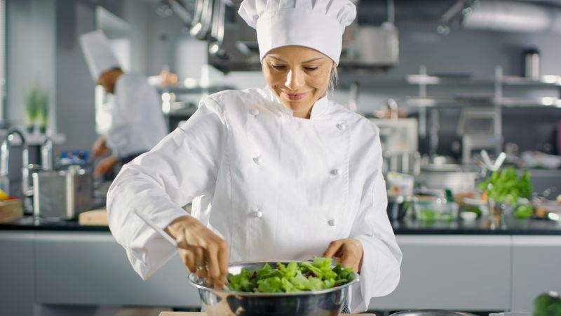In a Famous Restaurant Female Cook Prepares Salad. She Works in a Big Modern Kitchen.