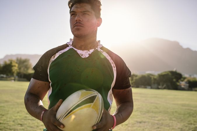 Rugby player holding a rugby ball on the sports field