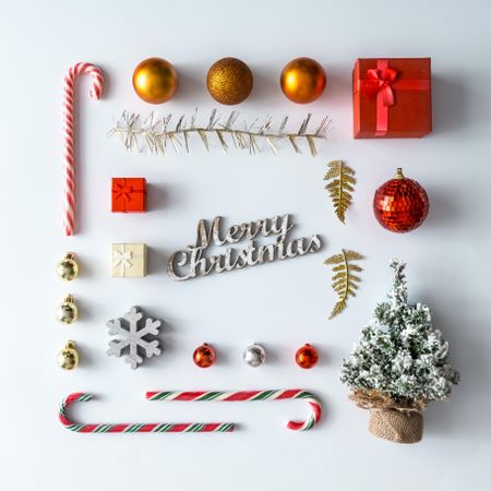 Christmas layout made of festive decorations, baubles, candy canes, presents on light background