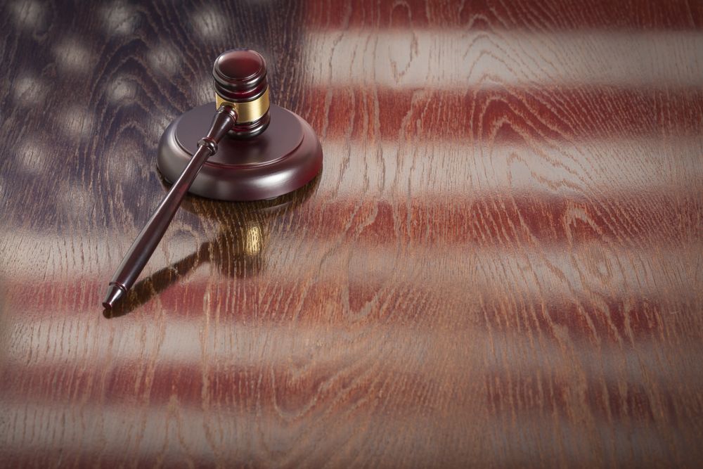 Wooden Gavel Resting on Flag Reflecting Table