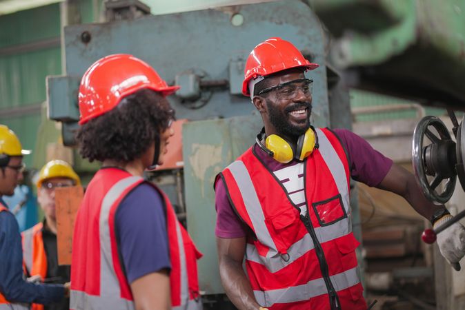 Two smiling Black colleagues in factory