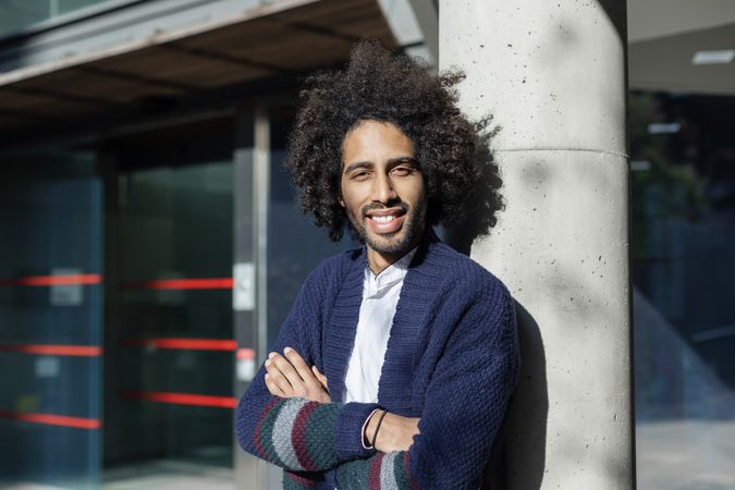Happy Black man standing with arms crossed on sunny day