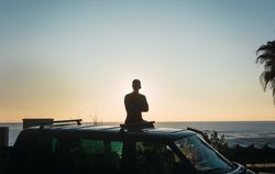 Man enjoying the sunrise in his camped van