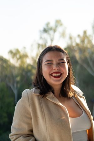 Young woman laughing with eyes closed and sun on hair