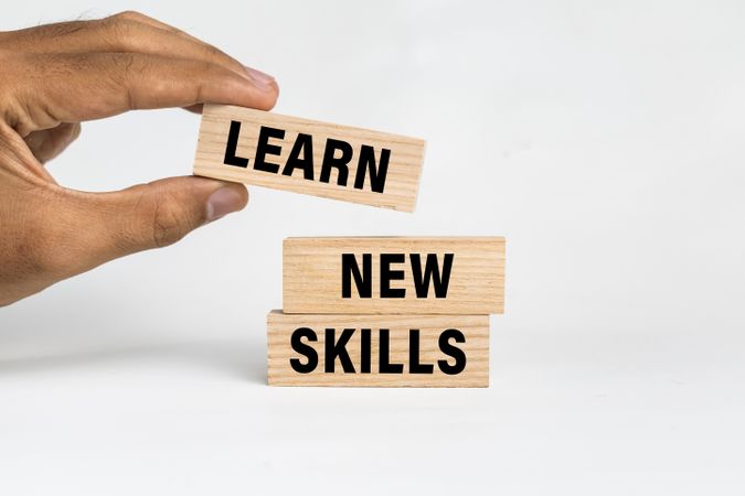 male hand put wooden blocks with learn new skills words text