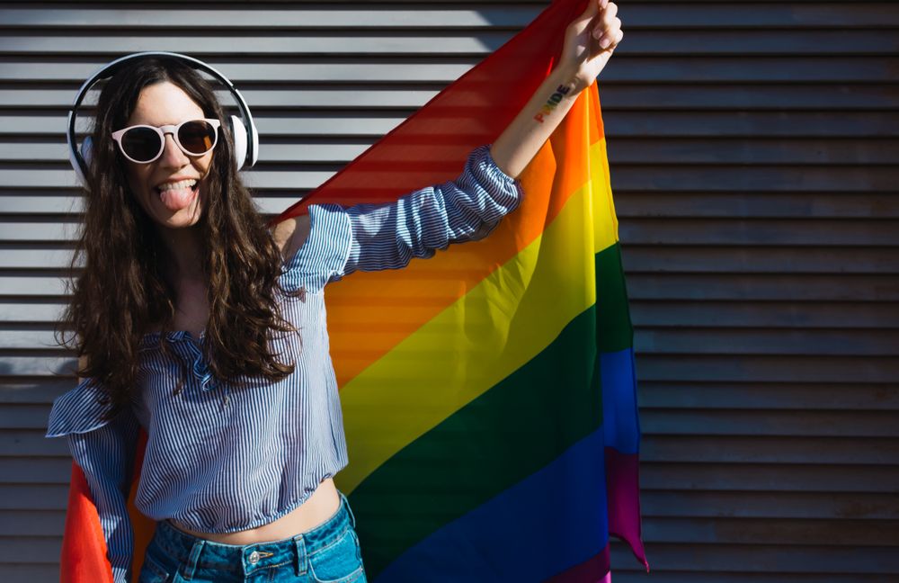 Woman posing happily with the LGBTQIA flag