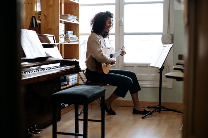 Woman playing guitar in studio