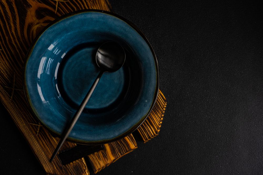 Rustic table setting with navy bowl and dark spoon