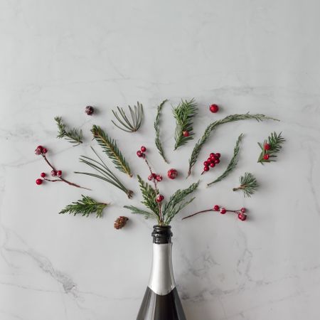 Champagne bottle with winter foliage on marble background