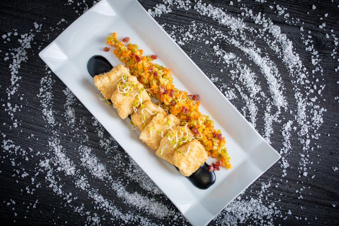 Hake breaded with matignon in rectangular plate