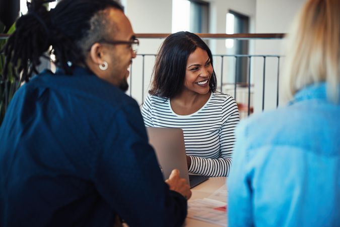 Black woman laughing with her team at work