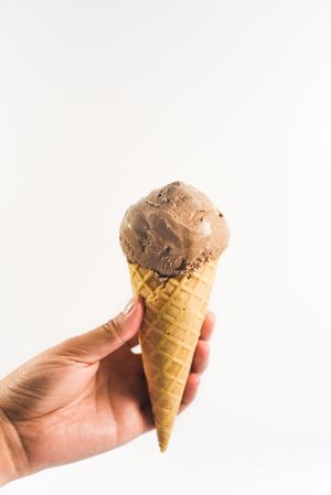 Hand holding chocolate ice cream cone