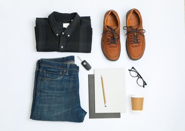 Flat lay composition with shirt, jeans, shoes and glasses on plain background