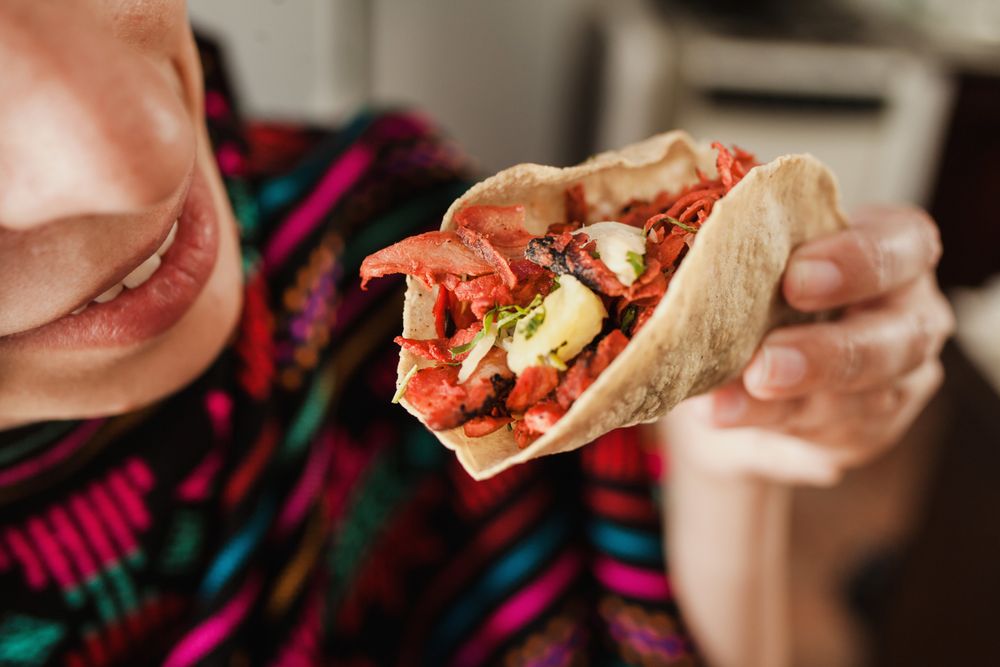 Crop woman with taco al pastor